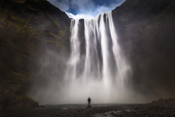 Skogafoss - May 04, 2018: Adventurer at the massive Skogafoss waterfall, Iceland