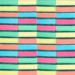 Many multi-colored sponges for washing dishes. Washcloths. Multi-colored texture. Multicolored rectangles.
