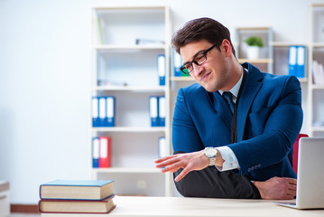 Fototapeta premium Businessman with broken arm working in office