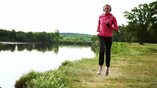 A morning jog in the Park near the pond in the Sunny rays of dawn, the girl is preparing to Mariano and lead a healthy lifestyle