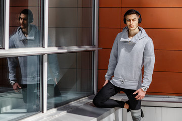 Portrait of young atractive fitness man with headphones outdoors
