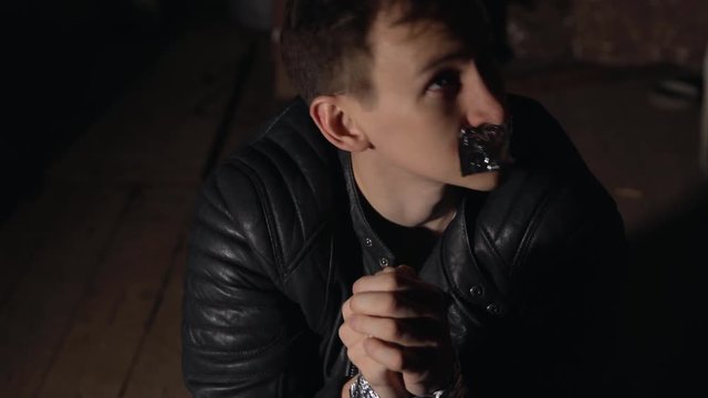 Abduction. A handsome man with a taped mouth and tied hands.