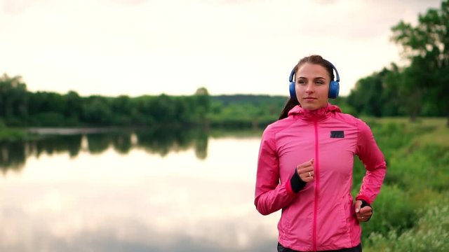 A morning jog in the Park near the pond in the Sunny rays of dawn, the girl is preparing to Mariano and lead a healthy lifestyle