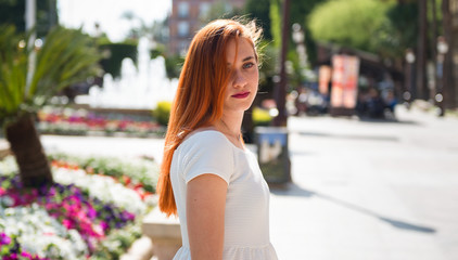 Young redhead pretty girl in a park