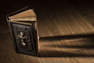 Precious antique Bible on a wooden desktop