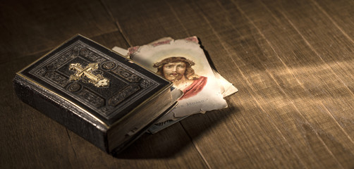 Sacred bible and Holy card with Jesus Christ image on a desk