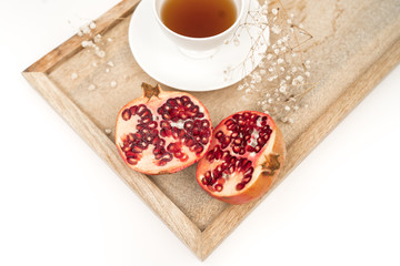 Fresh and Healthy Antioxidant Pomegranate Tea in the White Cup with Fresh Pomegranate Fruit and Seeds.