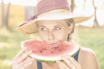 Beautiful happy young woman eating watermelon. Vegetarian food, holiday, diet concept.