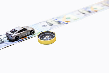 silver color car on the money road with gold compass to guide to the right direction to wealth, isolated on white background with clipping path