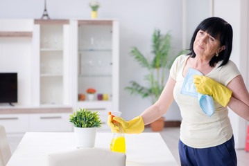 Old mature woman tired after house chores