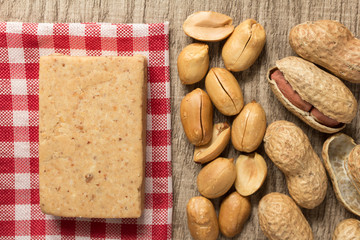 Pacoca is a candy with peanuts from Brazil. Sweet food of Festa Junina, a typical brazilian party. Snack over red plaid fabric.