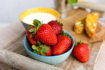 Fresh strawberries, milk, cookies on a wooden tray. Breakfast, healthy food. Selective focus.