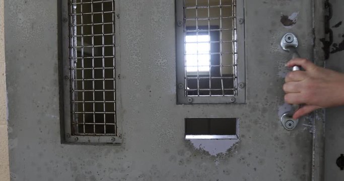 Hand pulling cell door closed with sound