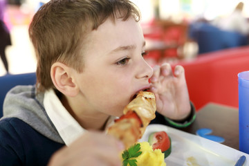 Child eating chiken kebab