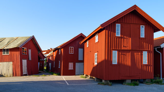 Old red wooden storage buildings in the harbor district of the village Mollosund on Orust, Sweden.