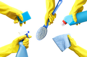 Hands in yellow rubber gloves hold a detergent, a rag, a bottle of spray, a brush, a sponge for cleaning the isolate. Close-up.
