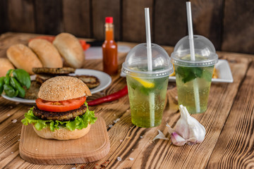 Tasty hamburger with meat and vegetables against a dark background. Fast food. It can be used as a background