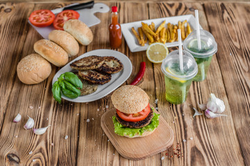 Tasty hamburger with meat and vegetables against a dark background. Fast food. It can be used as a background