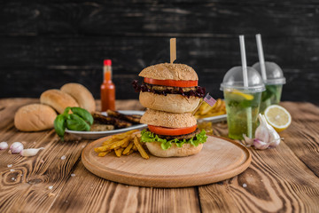 Tasty hamburger with meat and vegetables against a dark background. Fast food. It can be used as a background