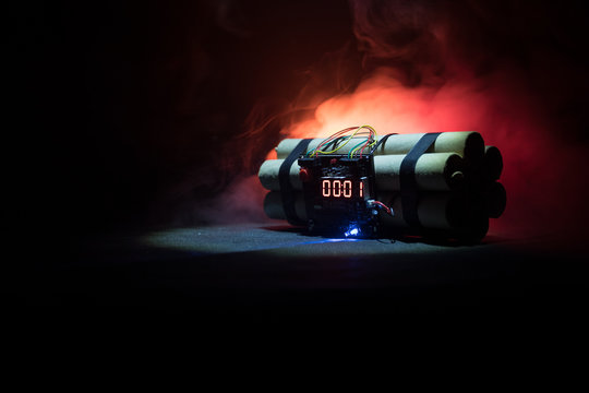 Image of a time bomb against dark background. Timer counting down to detonation illuminated in a shaft light shining through the darkness