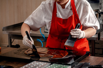 Step-by-step preparation of black designer candies. Preparation of chocolate glaze decorations for candy.
