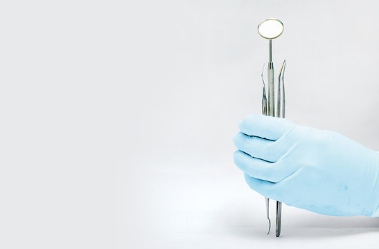 Holding Dental mirror and probe and tweezer isolated in white background