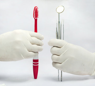 Holding Dental mirror and probe and tweezer amd toothbrush isolated in white background