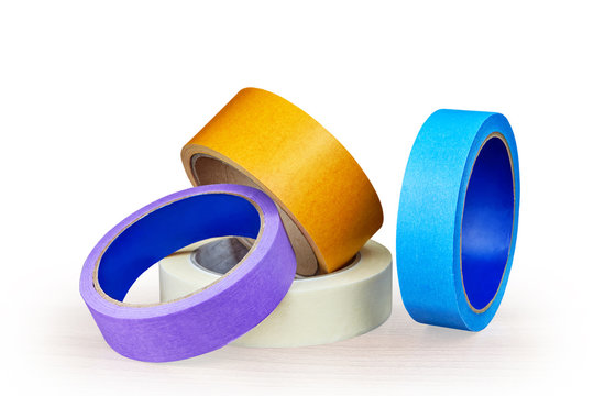 Blue, purple and yellow rollers of adhesive tape on white.