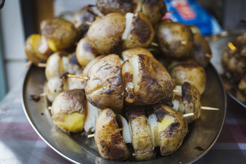 Potato skewers with bacon on wooden skewers close-up