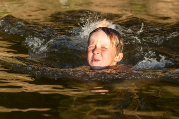 Little boy swimming in the river