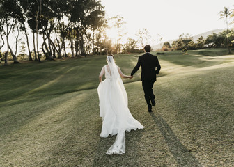 Bride and Groom running towards sunset
