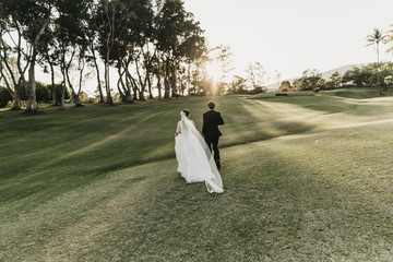 Bride and Groom running towards sunset