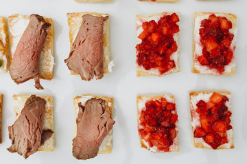 delicious small sandwiches with meat on a white plate for guests of a luxurious restaurant