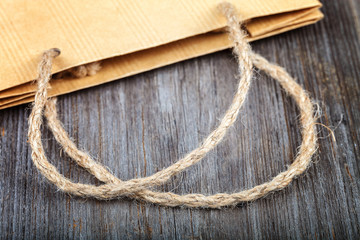Paper bag with rope handles on a wooden background
