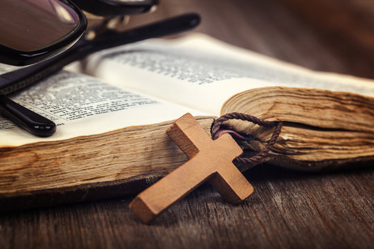 Ancient holy book of a wooden cross on a cord.