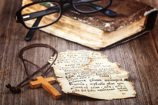 Ancient holy book of a wooden cross on a cord.