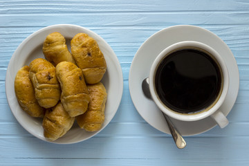 a cup of coffee with croissants  from the top