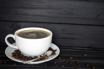 copy spaсe,  cup of coffee in a bowl with coffee beans on a dark wood background