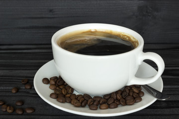  cup of coffee in a bowl with coffee beans on a dark wood background