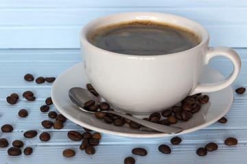a cup of coffee in a bowl with coffee beans