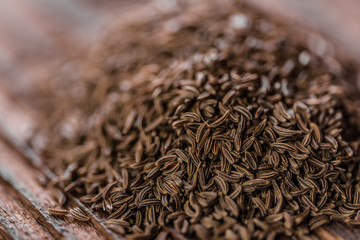 close up of heap of cumin on wood table