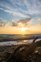 Amazing sea sunset on the pebble beach, the sun, waves, clouds
