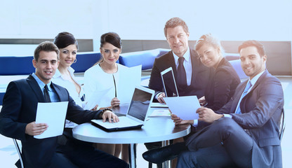 group of business people with documents sitting at a table in the lobby of the Bank.