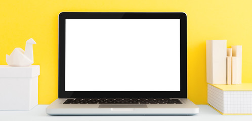 Laptop screen mockup on creative yellow desk.