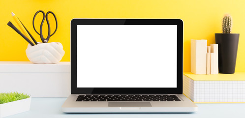 Laptop screen mockup on creative yellow desk.