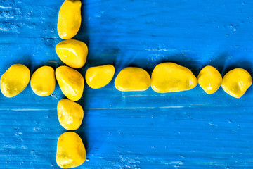 original flag of Sweden from yellow stones on a blue background 
