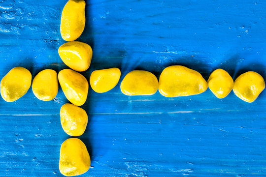 original flag of Sweden from yellow stones on a blue background 