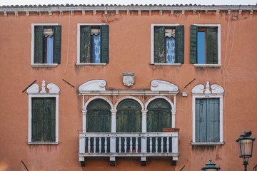 Fototapeta na wymiar Tradional windows and balconies of an old building in Venice, Italy