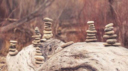 Fototapeta na wymiar several towers of stacked rocks toned with a retro vintage instagram filter