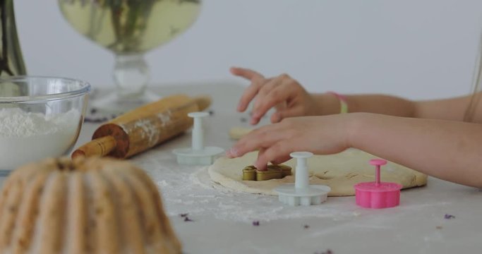 Preschooler prepares pastries, child play with pastry. Cute little girl are playing and smiling while baking in kitchen at home
